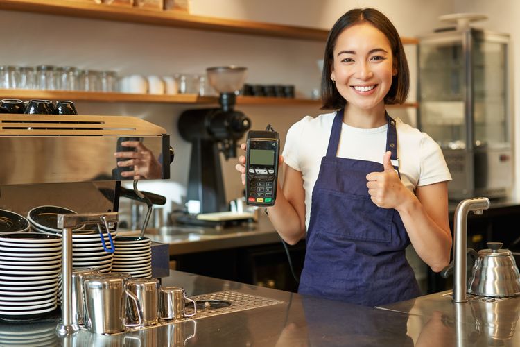 Suasana barista mengoperasikan mesin kopi dan POS system digital di coffee shop modern