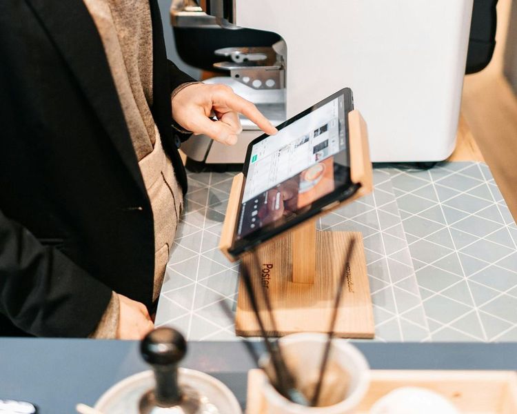 Illustration eines indonesischen KMU-Unternehmers, der die digitale Kassensoftware Rebill POS an einer modernen Verkaufstheke nutzt – mit Thermodrucker und Tablet mit Touchscreen.